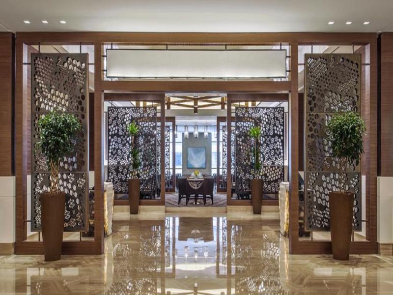 Hotel Jabal Omar Hyatt Regency Makkah La La Mecca Esterno foto The photo depicts the interior of an elegant restaurant or lobby space. There are large decorative partitions that create a sense of separation and intimacy, featuring intricate designs. On either side of the partitions, there are tall decorative pla