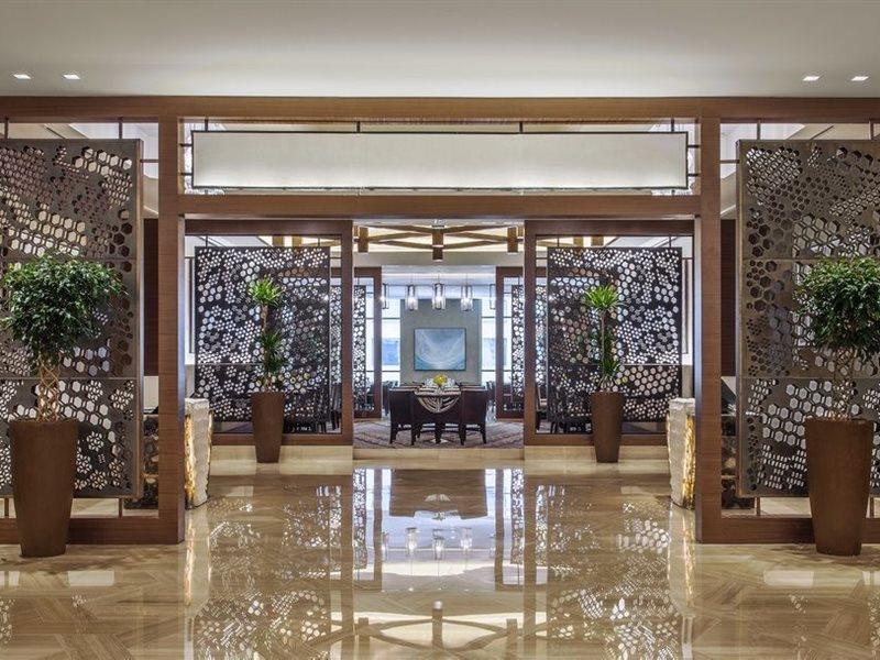 Hotel Jabal Omar Hyatt Regency Makkah La La Mecca Esterno foto The photo showcases a modern, elegant interior space, likely within a hotel or upscale establishment. It features decorative screens made of intricate patterns that serve as partitions. The floor is polished marble, reflecting the bright lighting abo