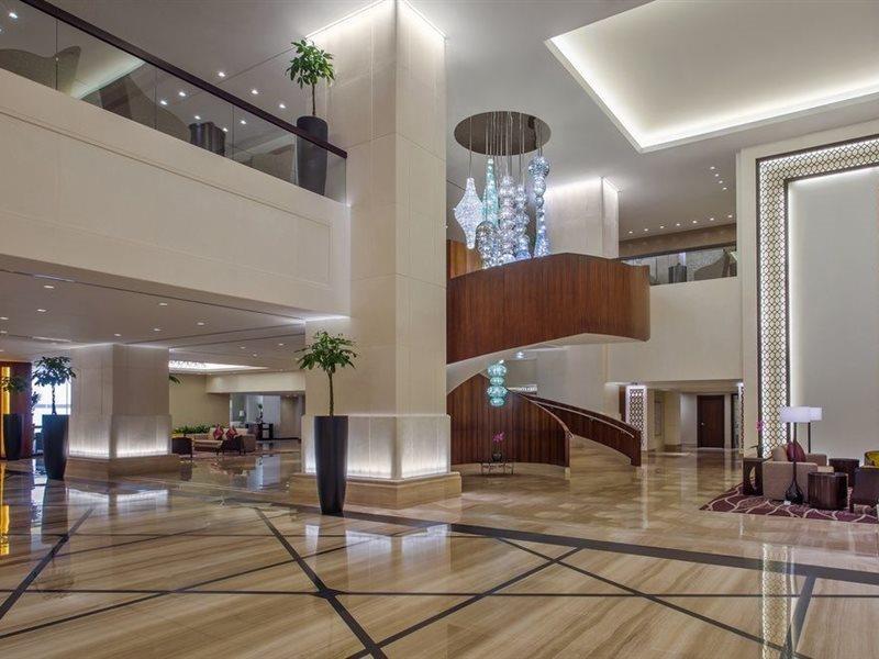 Hotel Jabal Omar Hyatt Regency Makkah La La Mecca Esterno foto The image shows a spacious and modern hotel lobby. It features elegant interior design with high ceilings and polished marble floors. A prominent wooden staircase with a stylish design is located in the center, leading to an upper level. There are de