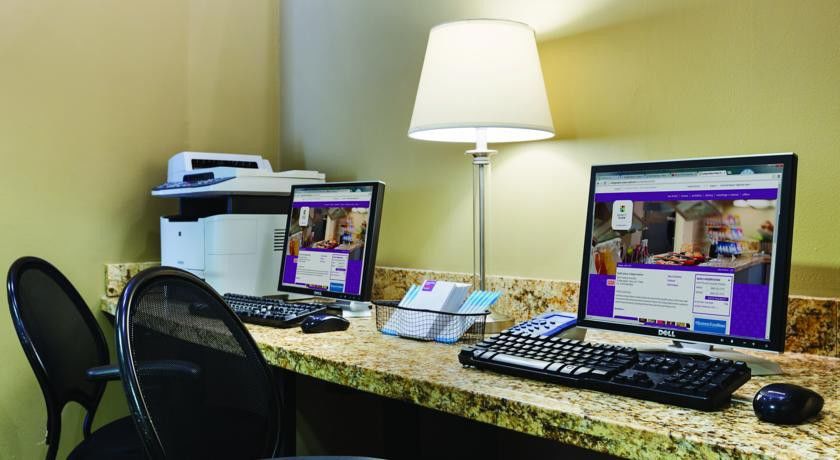 Hotel Jabal Omar Hyatt Regency Makkah La La Mecca Esterno foto The photo shows a small workstation area featuring two computer monitors on a granite countertop. Each monitor has a keyboard and mouse in front of it. Alongside the computers, there is a lamp providing illumination. To the left, a printer is visible