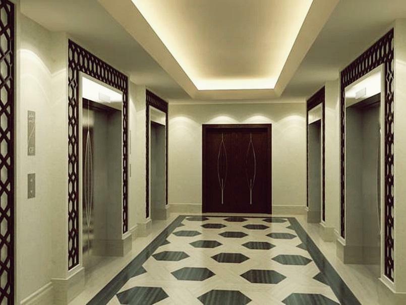 Hotel Jabal Omar Hyatt Regency Makkah La La Mecca Esterno foto The photo shows a modern, elegantly designed hotel hallway. It features a symmetrical layout with two sets of elevators on either side. The walls are a soft cream color, which enhances the overall brightness of the space. A sophisticated pattern can 